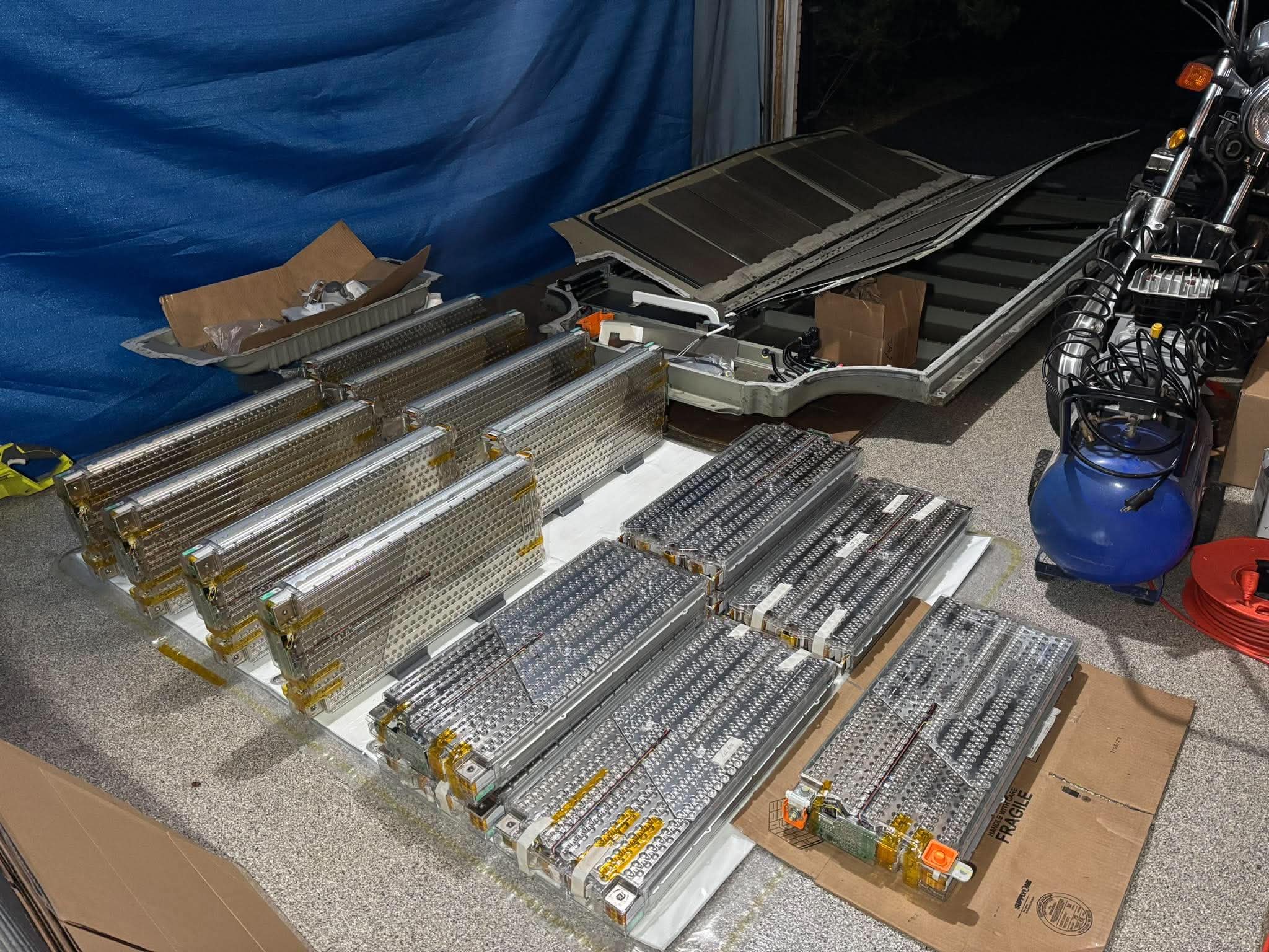 Battery modules and an opened battery pack laid out in our workshop